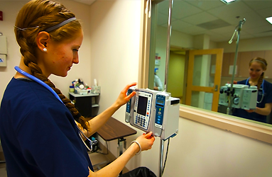 Nurse checks the monitor on a patient's IV stand